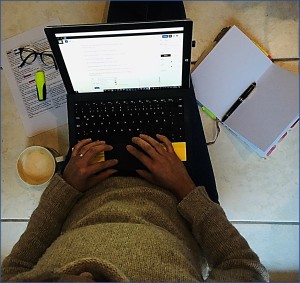 Aqui puedes ve a una pesona escribiendo en su computadora, junto a ella hay una página escrita.